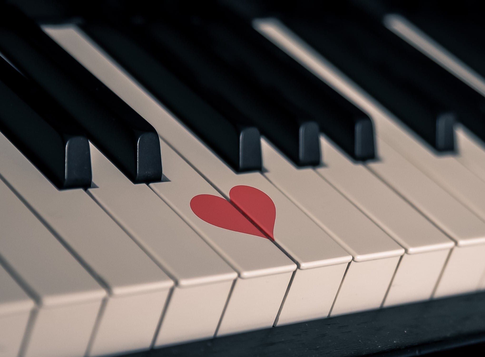 A small red heart painted on the piano keys